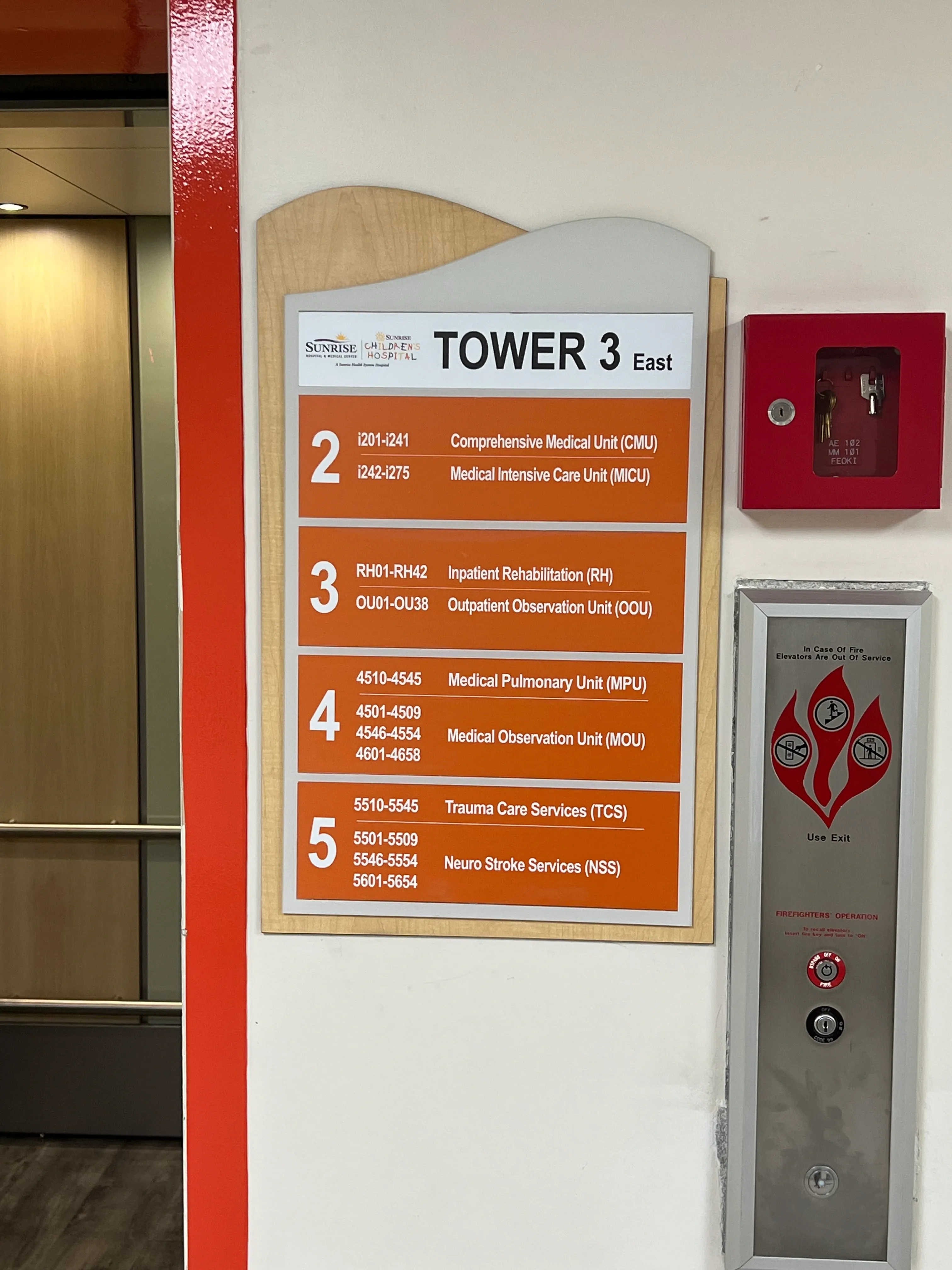 Hospital wayfinding sign and elevator entrance labeled Tower 3