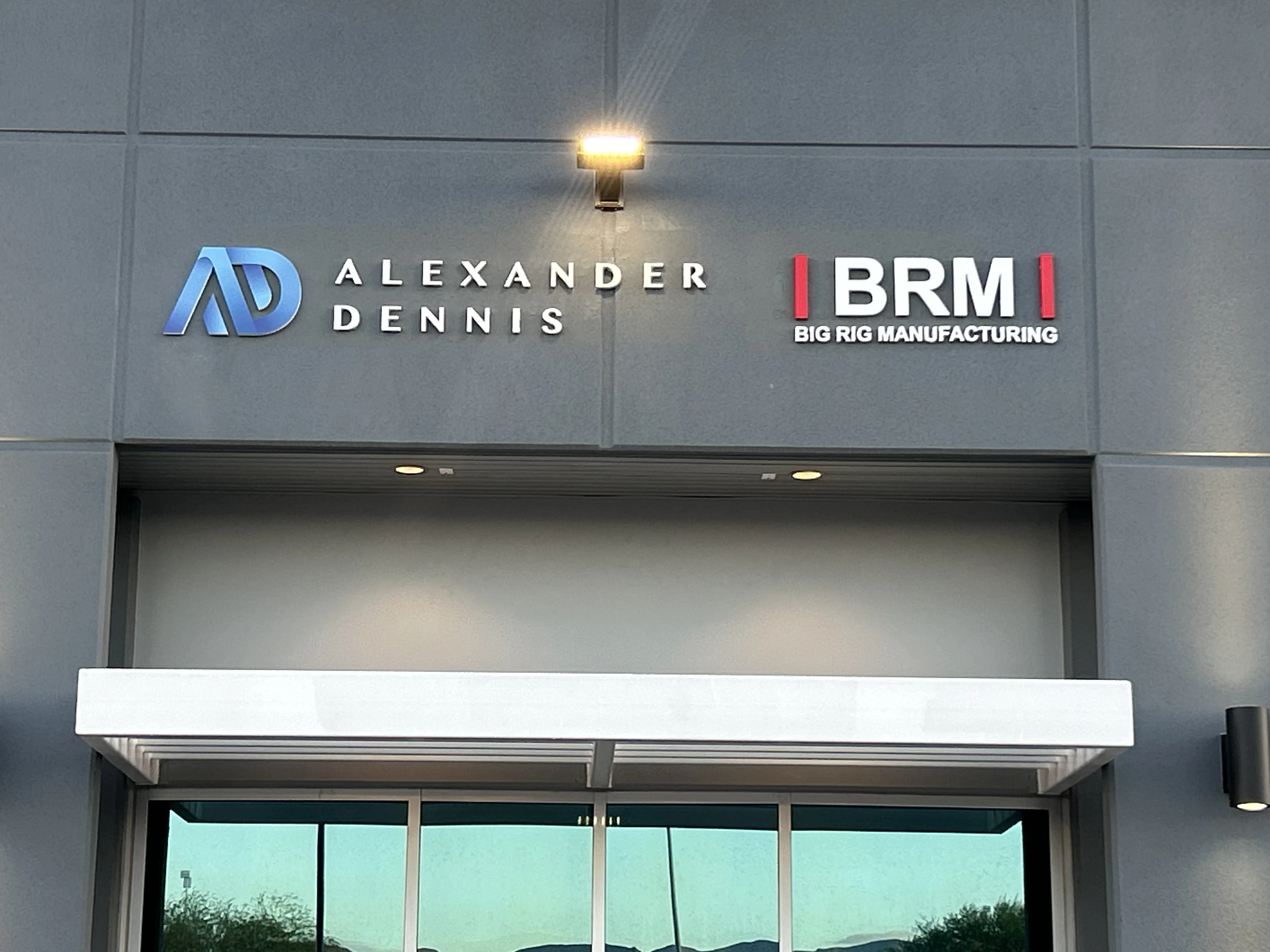 Building signage illuminated by lamp for Alexander Dennis and BRM Big Rig Manufacturing.