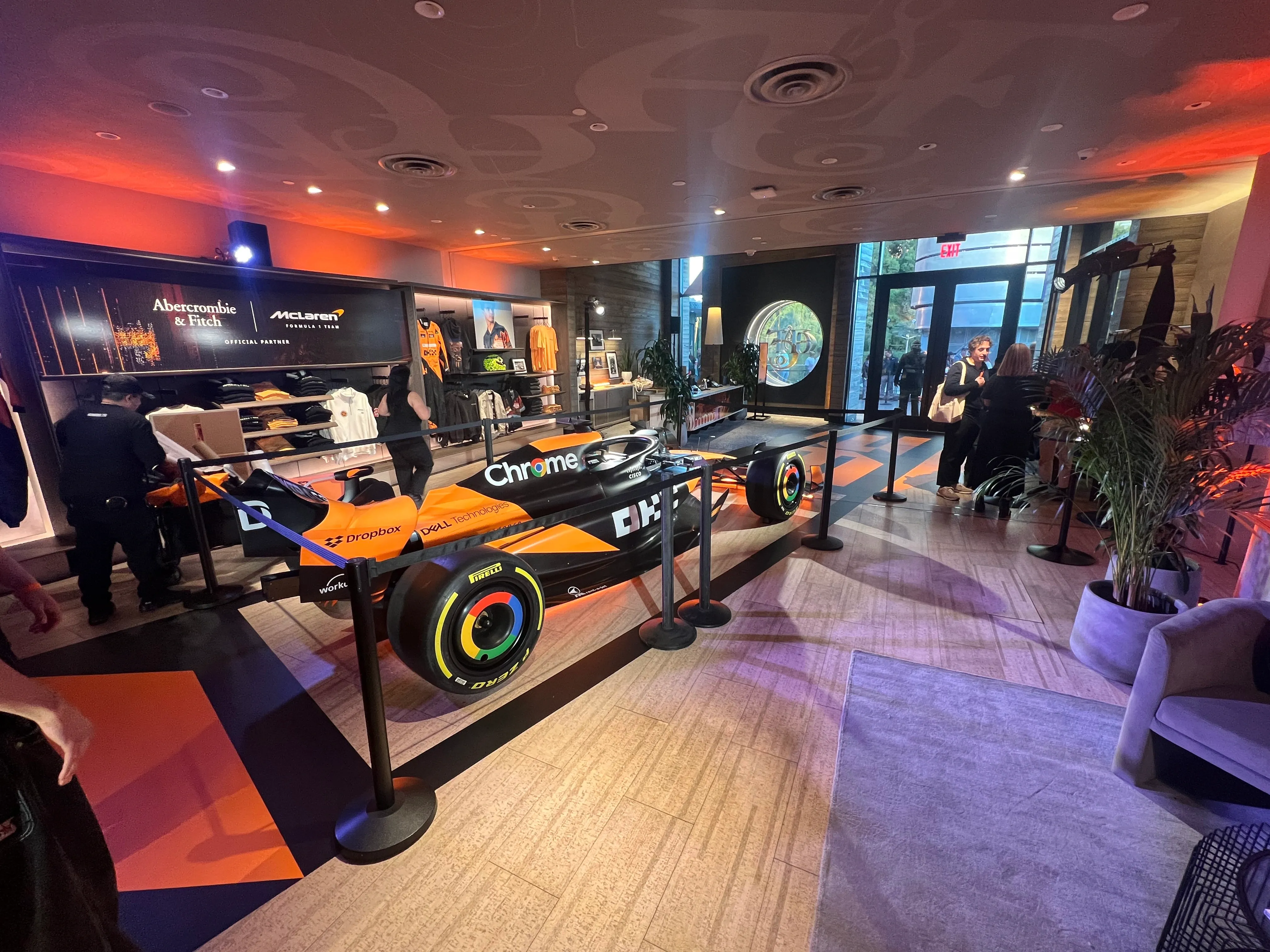 Custom-wrapped McLaren Formula 1 racecar on display inside a Las Vegas retail space, showcasing high-impact vehicle graphics under ambient lighting.