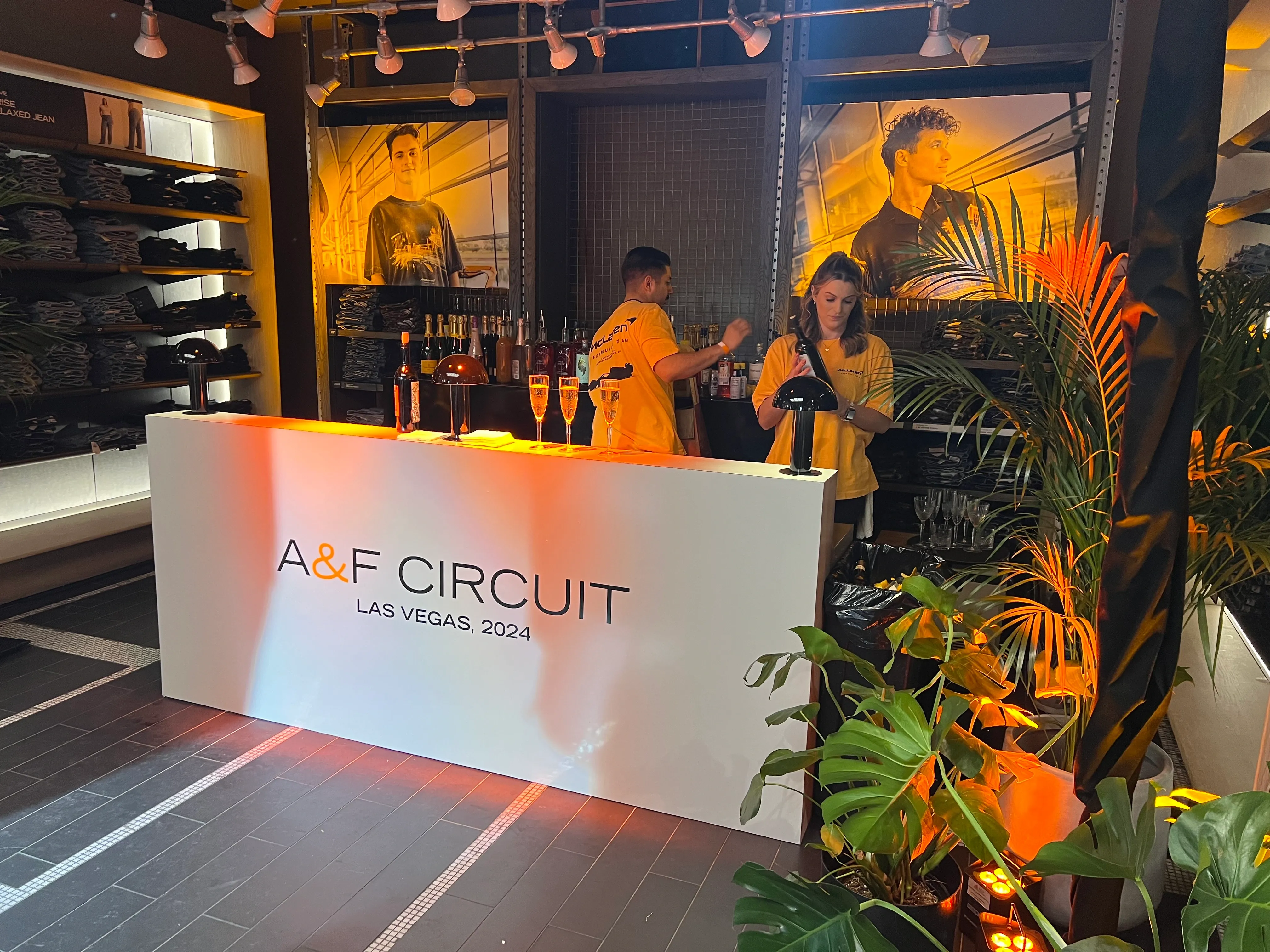 Branded white vinyl-wrapped kiosk bar with “A&F Circuit Las Vegas 2024” logo, serving guests at an F1-themed experiential retail activation.