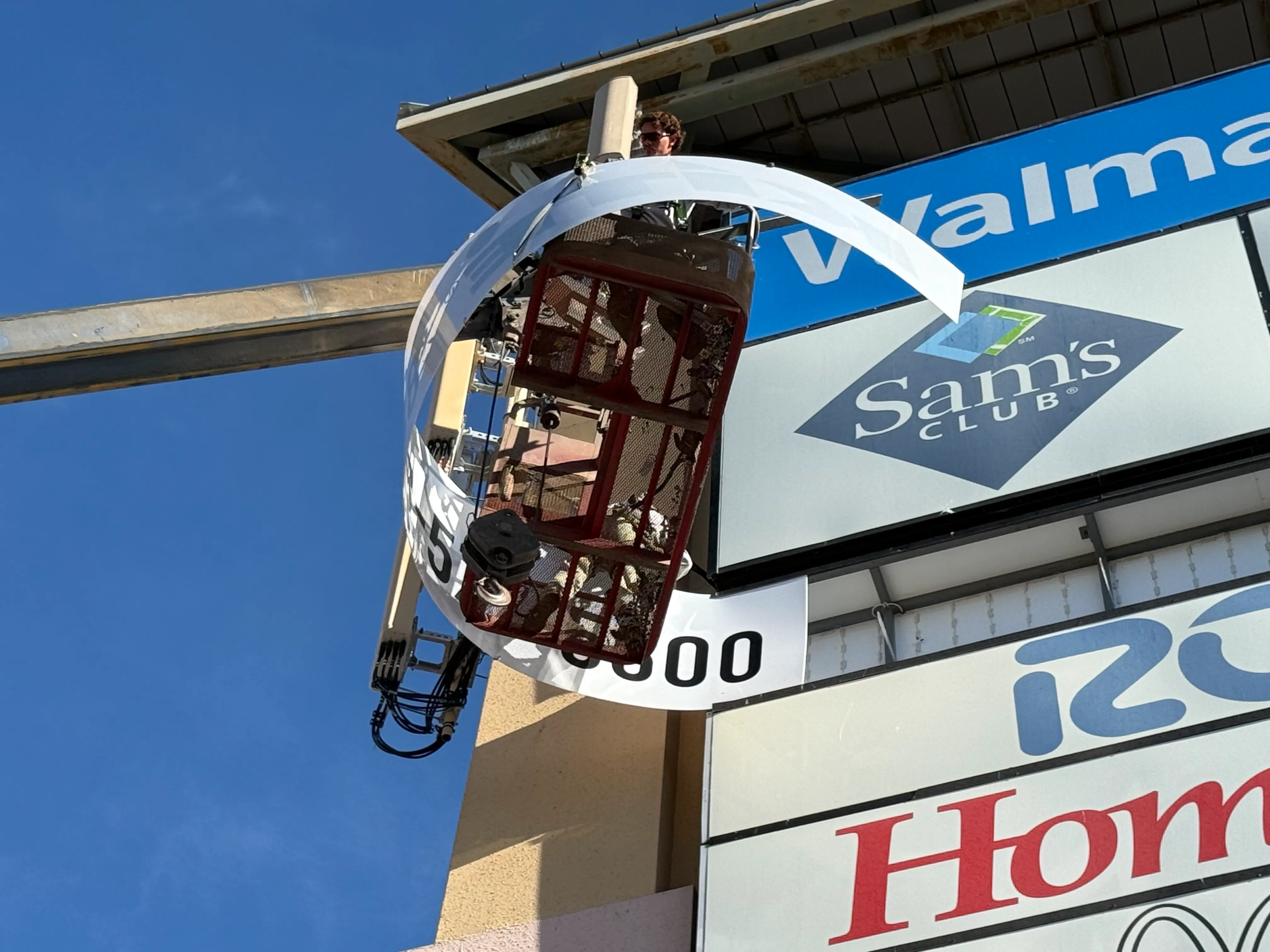 Technicians performing high-elevation pylon sign installation