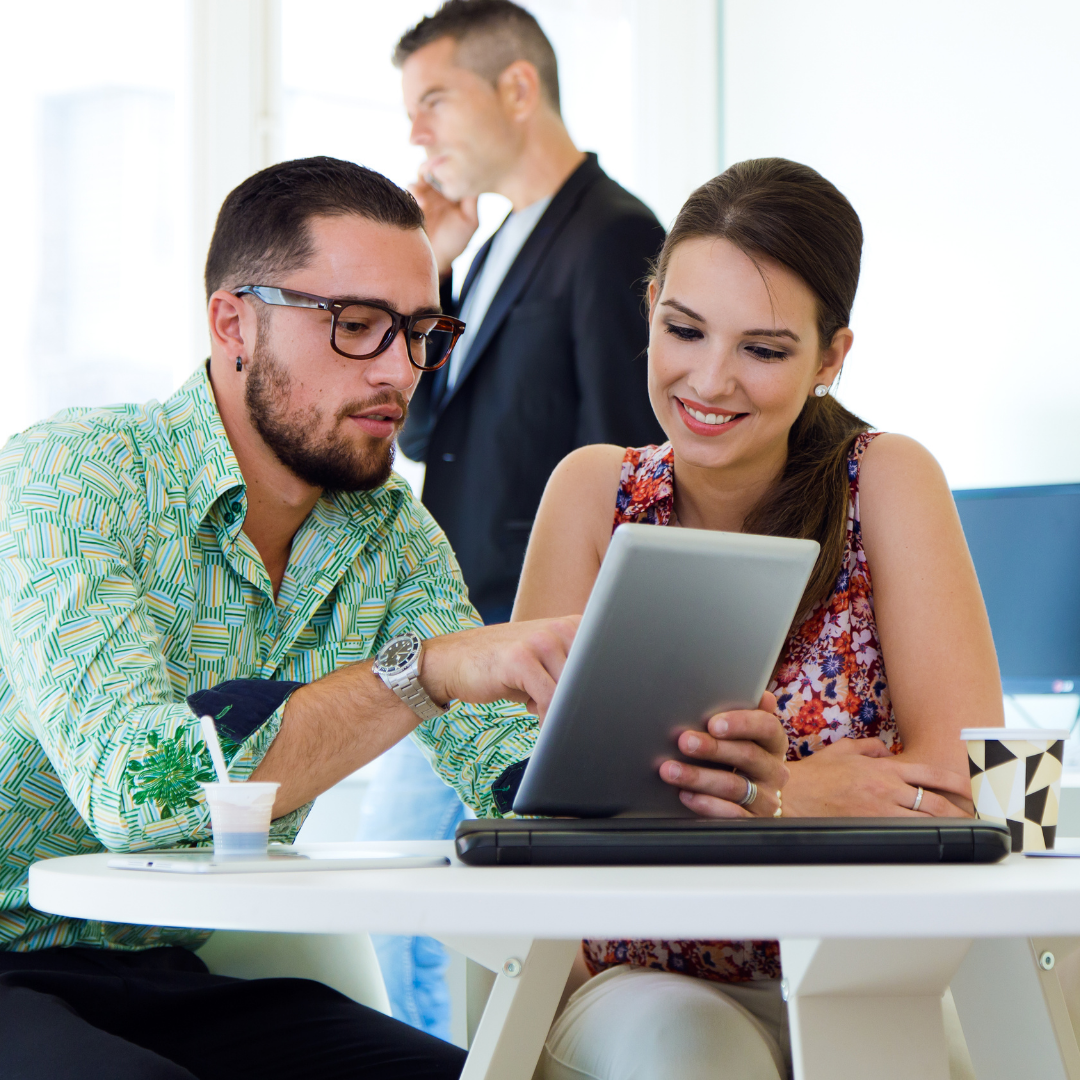 man and woman looking at ipad